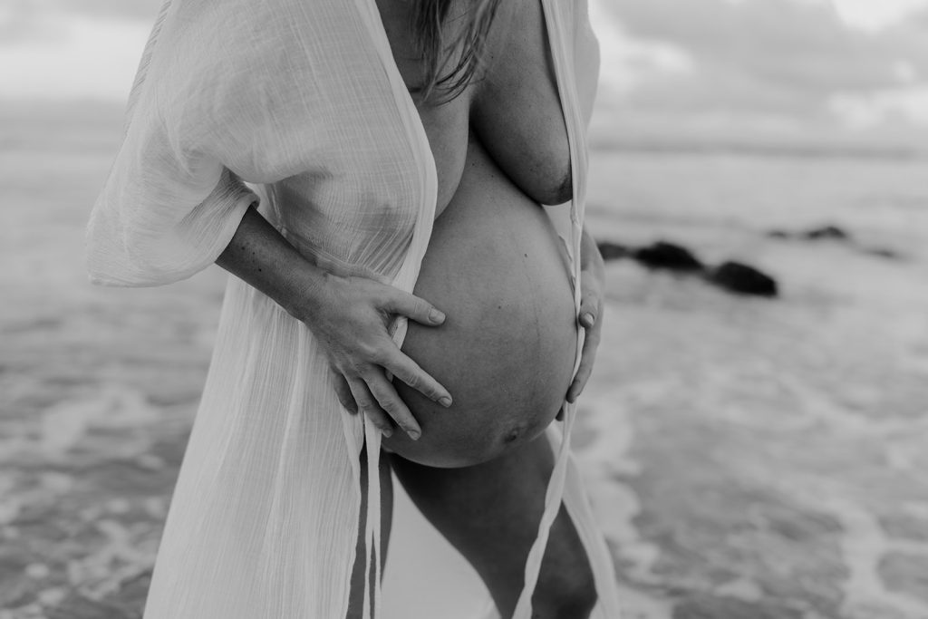 black and white image of a close up pregnant belly